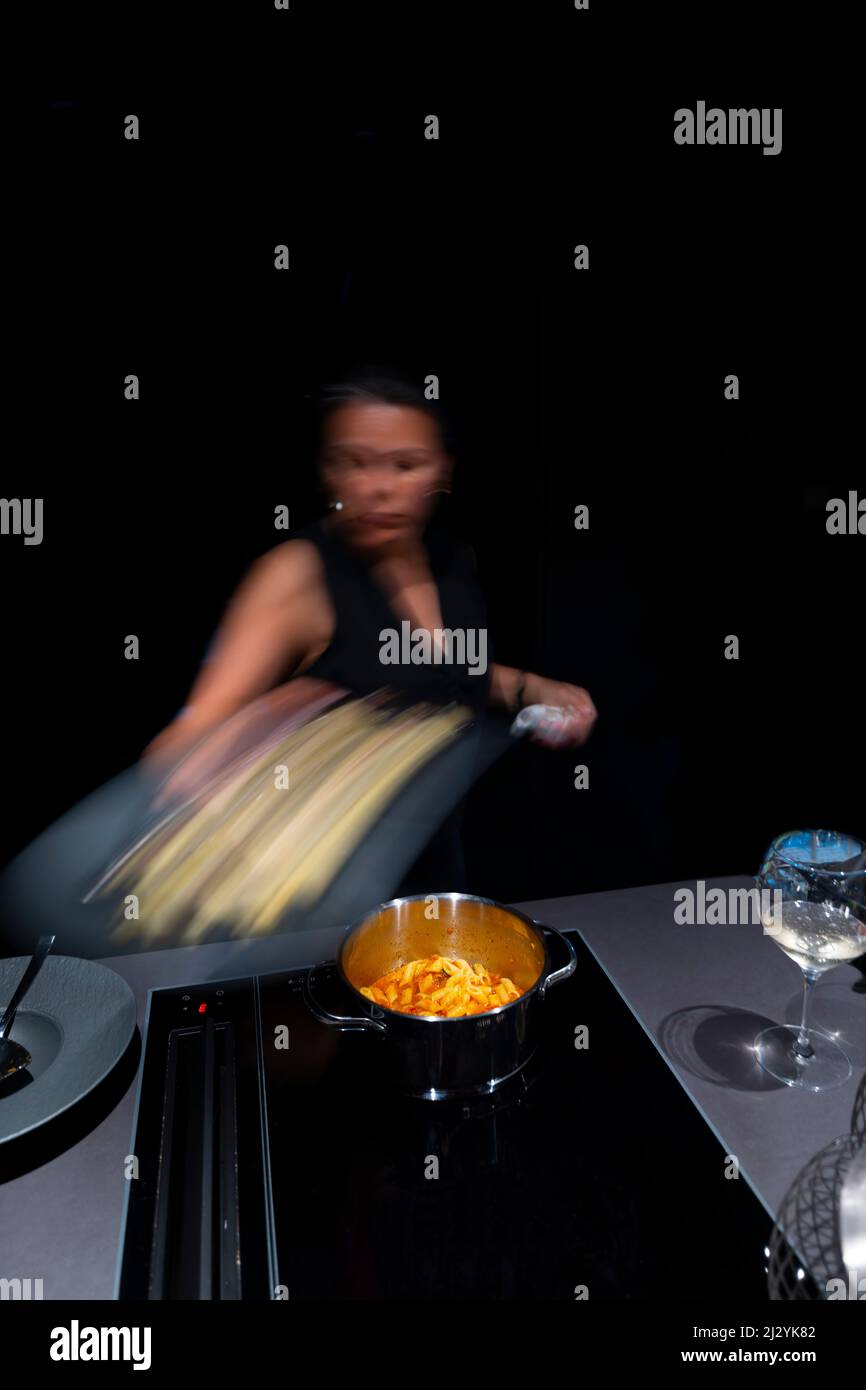 Woman Making Pasta in Kitchen in Long Exposure in Switzerland. Stock Photo
