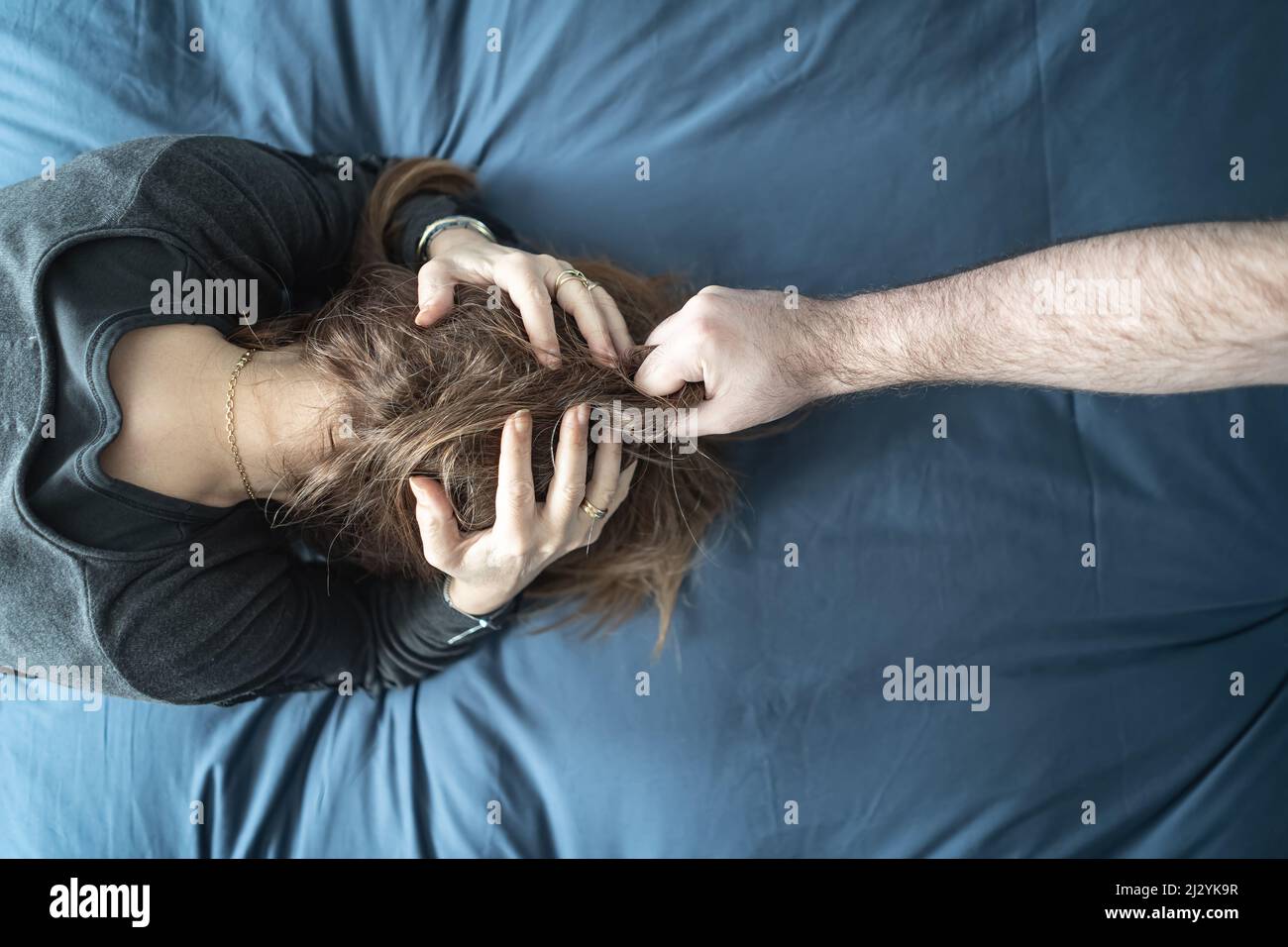 Man assaulting his wife in the home, scene of gender violence against women. Stock Photo
