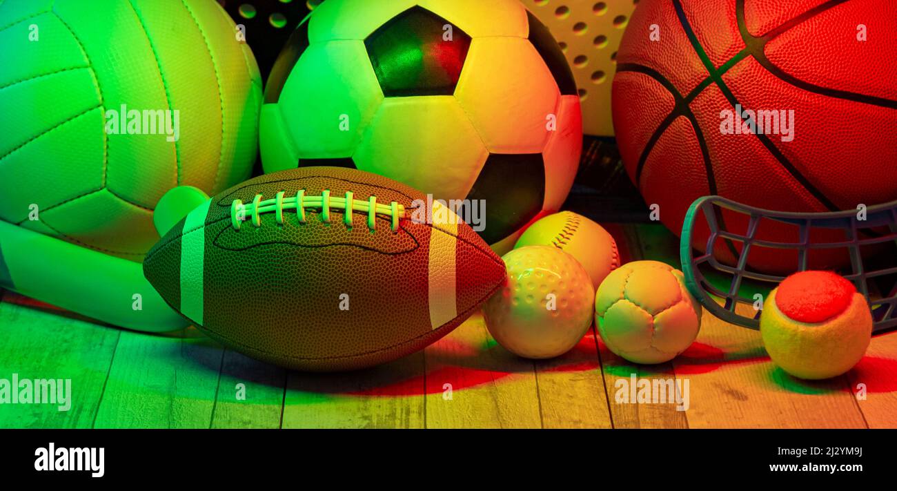 Sports equipment, rackets and balls on hardwood court floor with neon
