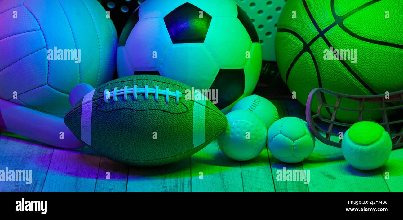 Sports equipment, rackets and balls on hardwood court floor with neon