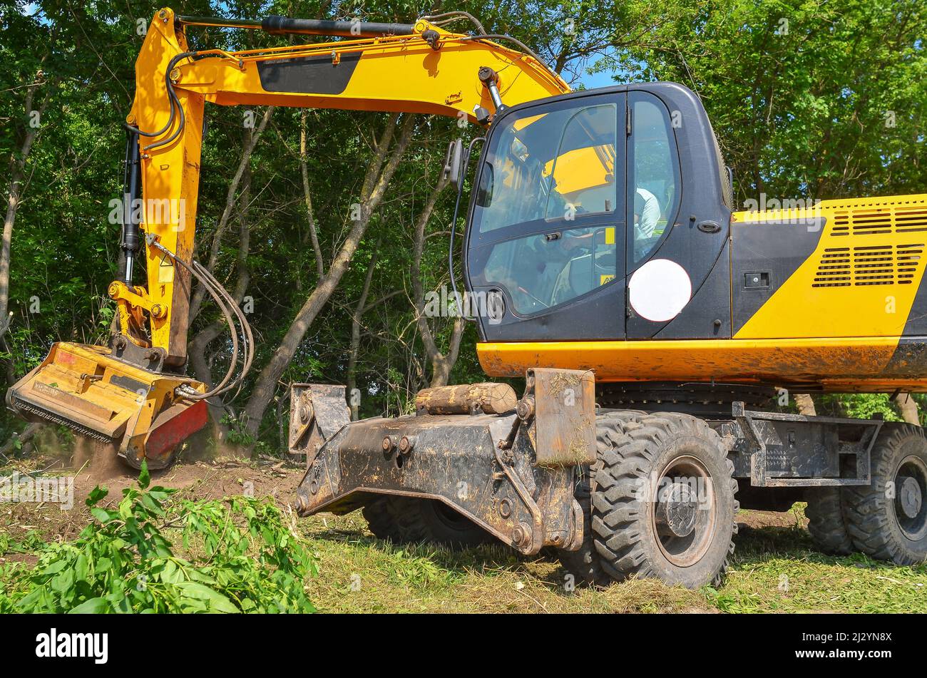 Roadside cleaning device. Mulcher. Processing of branches and vegetation Stock Photo