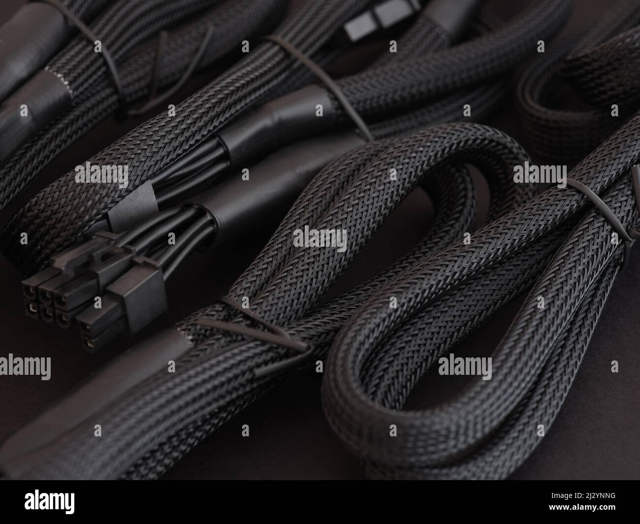 The cables for a high performance power supply in a heap. Low key. Close up. Stock Photo