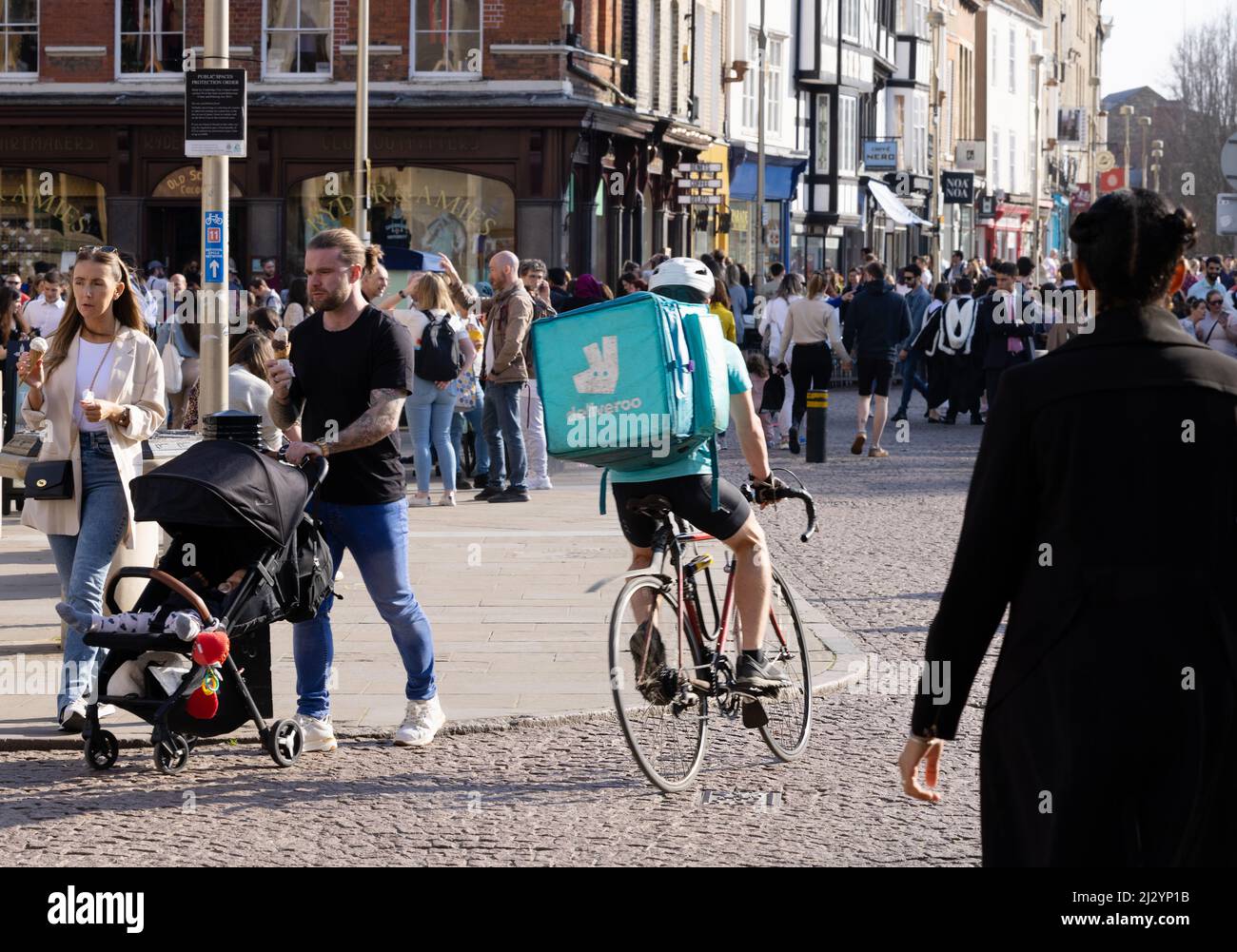 Deliveroo rider; Deliveroo cyclist delivering food, rear view, Cambridge UK Stock Photo