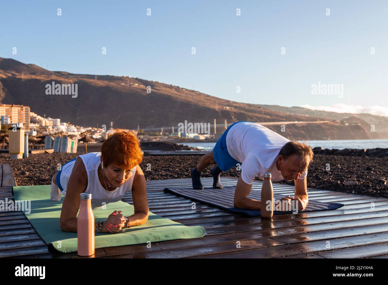 Senior couple doing exercises by the sea Stock Photo - Alamy