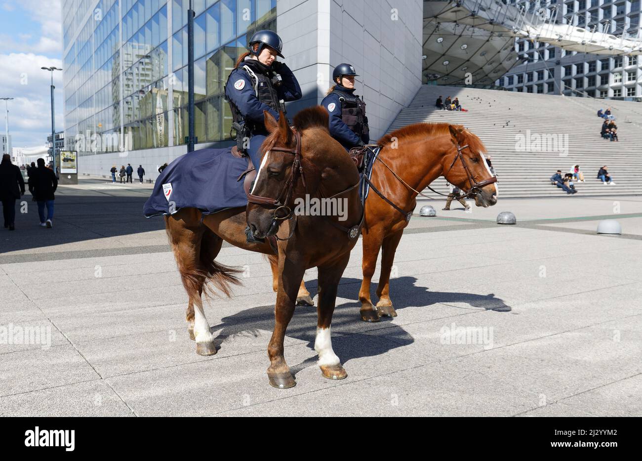 Two mounted police officers on horses are patrolling through the walkway of the seine river in downtown of Paris Stock Photo