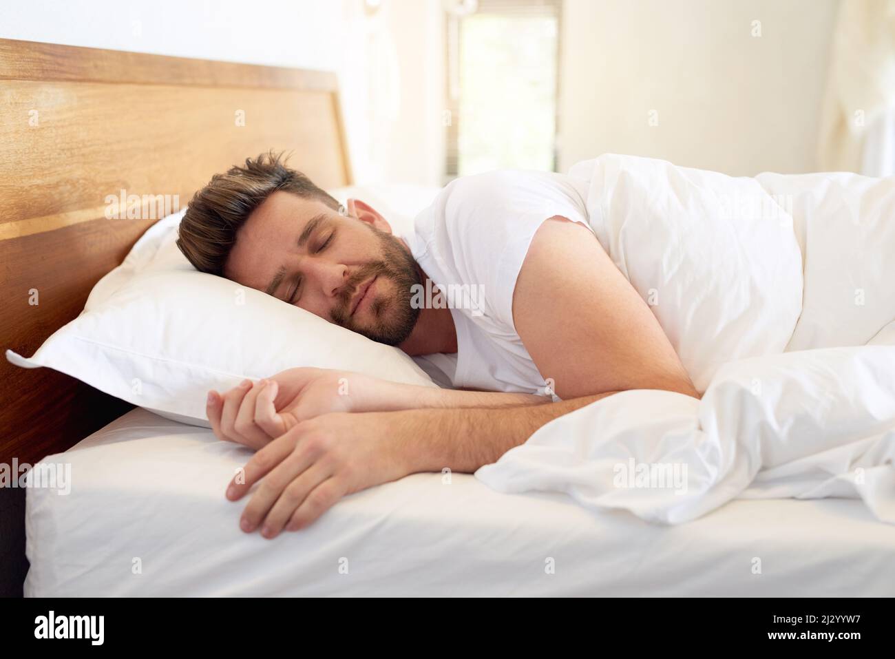 Time to enjoy a weekend lie-in. Cropped shot of a young man sleeping peacefully in bed at home. Stock Photo