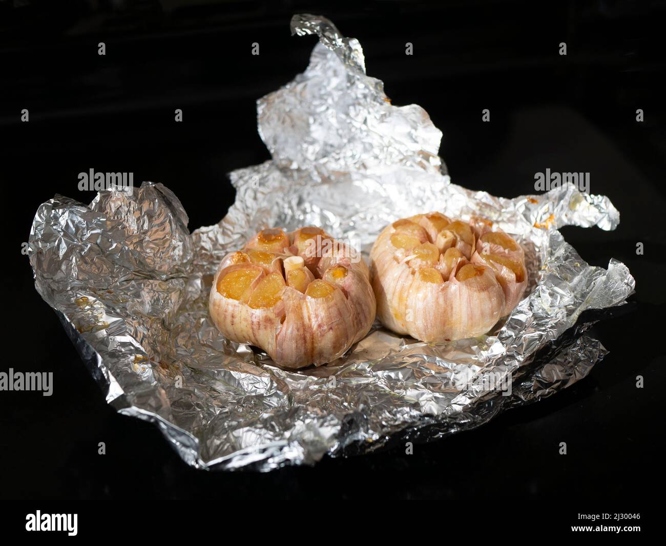 Bulbs of baked garlic. Cooking garlic before use. Roasted garlic in