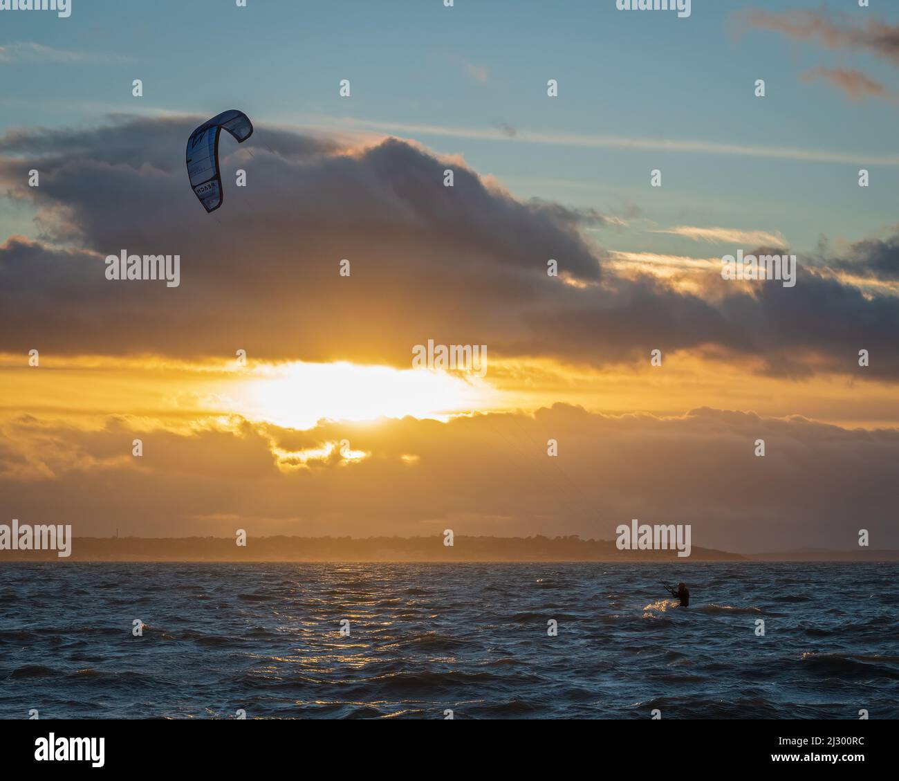 Kite surfers making the most of a windy day on the Solent, just of the beach in Stokes Bay, Gosport, Hampshire, England, UK. Stock Photo