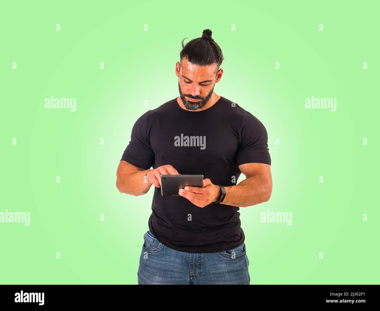Attractive muscular man using electronic tablet in studio Stock Photo