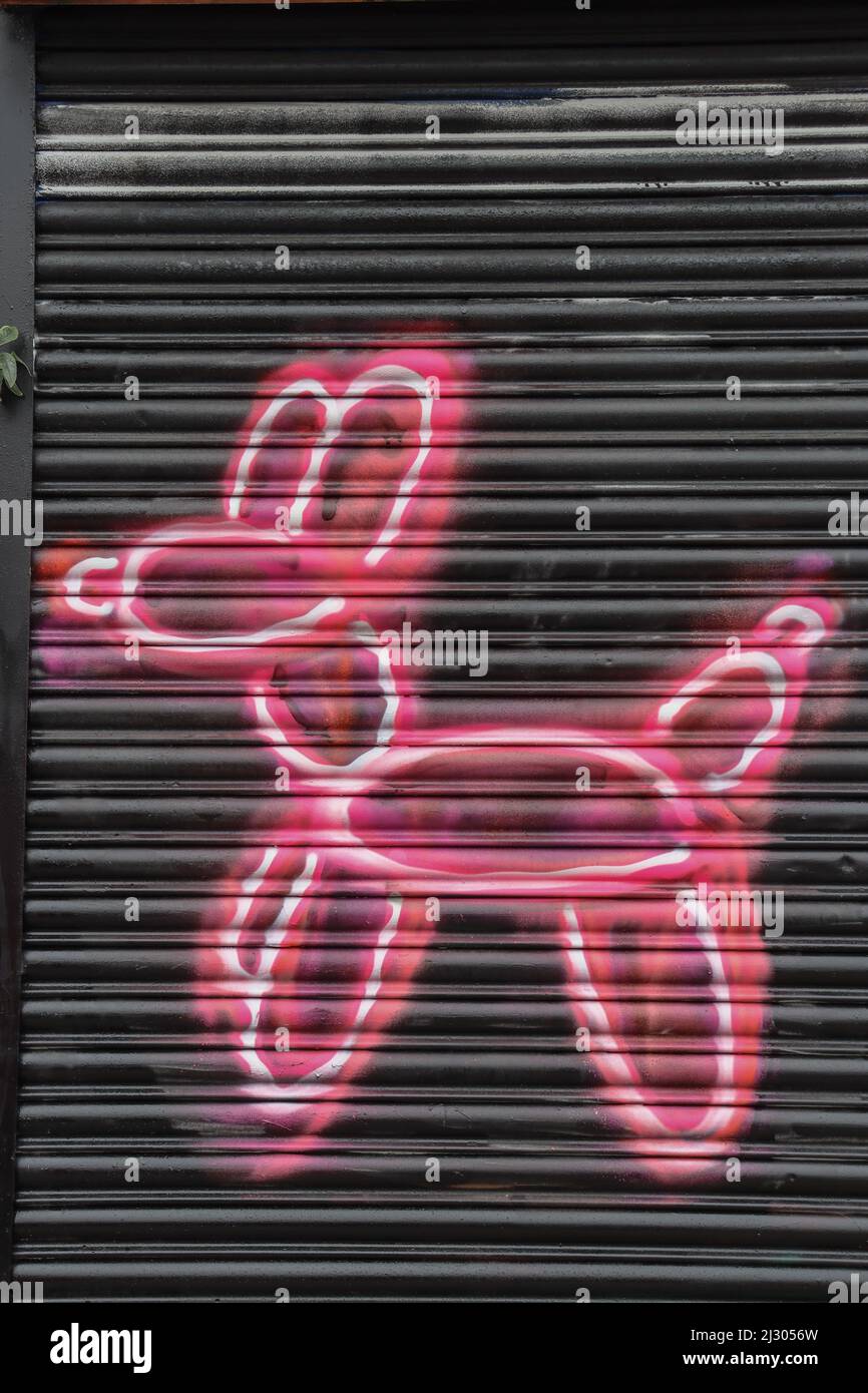 Neon Pink Balloon dog street art on metal shutters Stock Photo