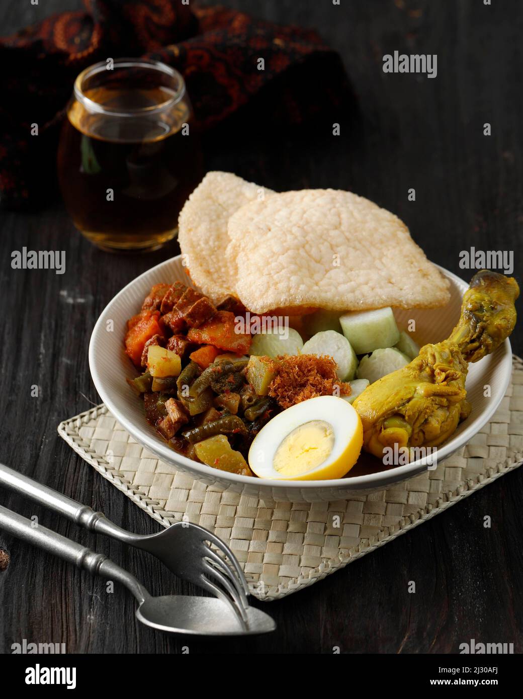 Ketupat Sayur or Lontong Sayur Lebaran Komplit, Dish usually Served during Ramadhan or Idul Fitri. On Wooden Table, Served with Tea Stock Photo