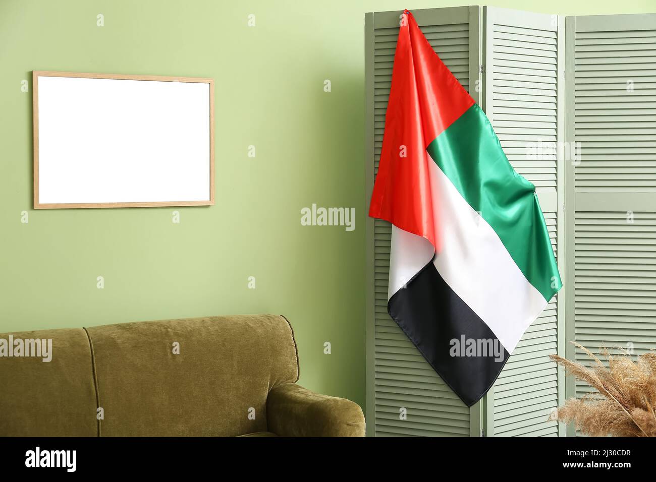 UAE flag hanging on folding screen near green wall Stock Photo Alamy