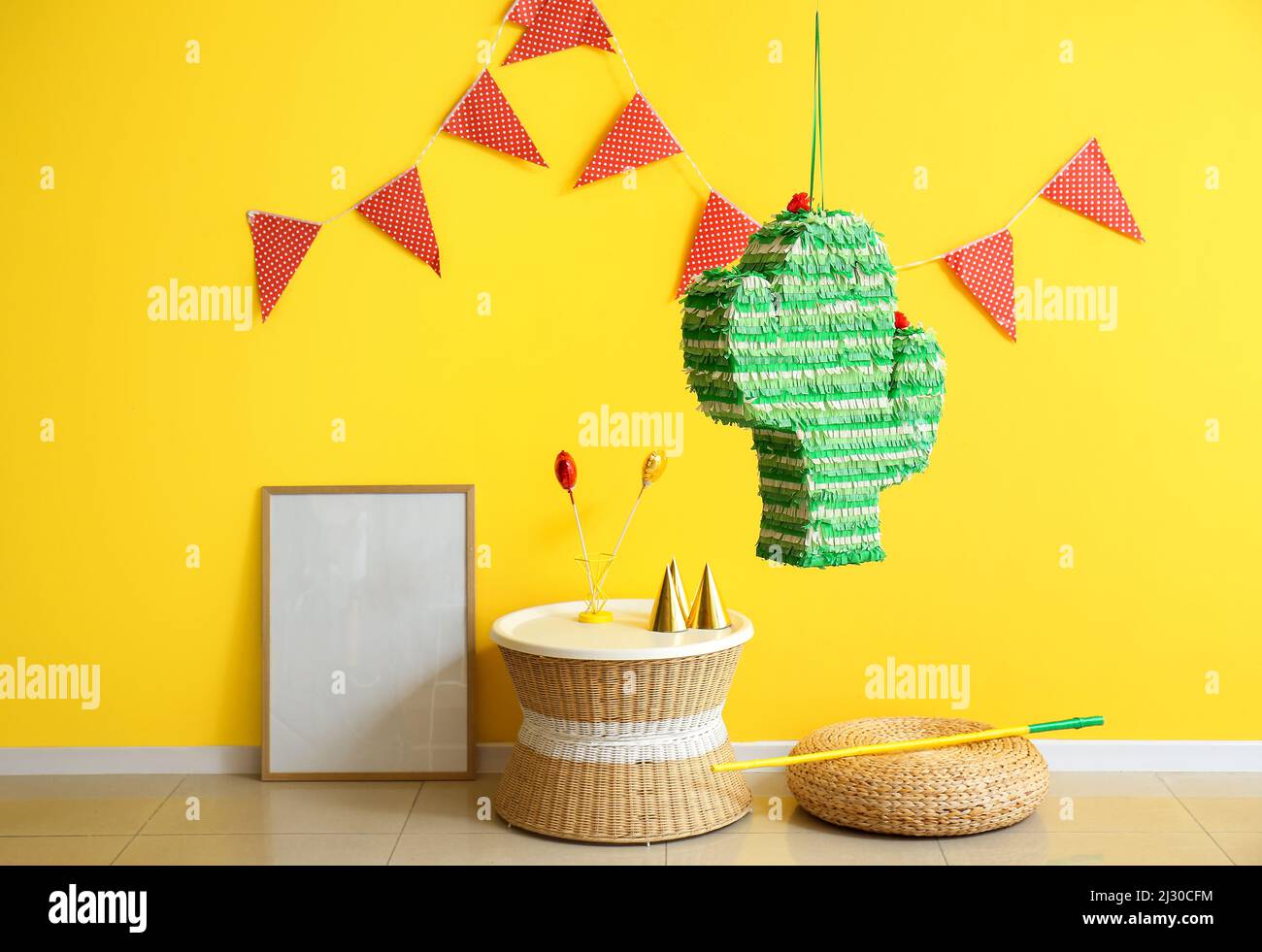 Interior of stylish room with hanging Mexican pinata, table and frame ...