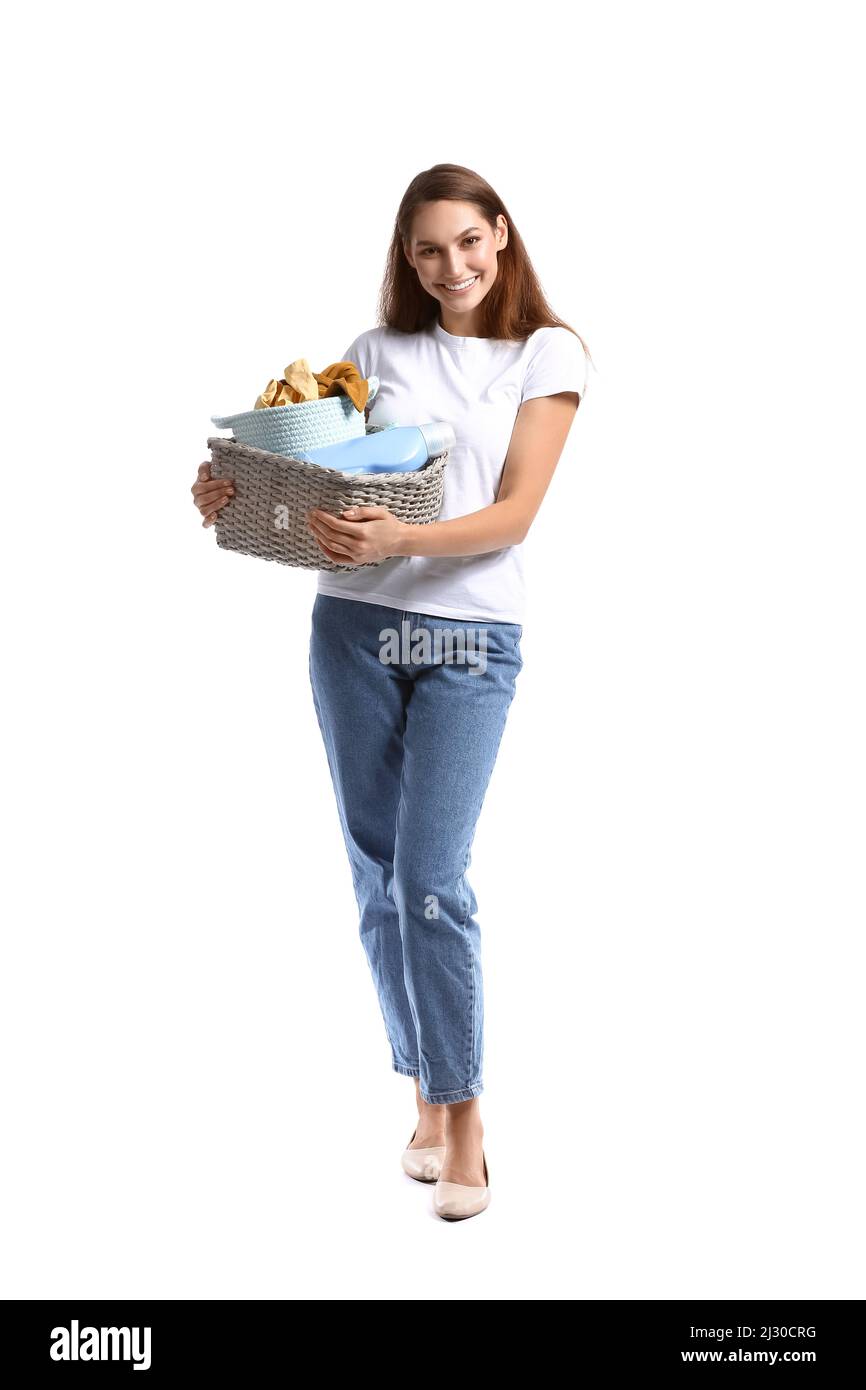 Beautiful woman holding wicker basket with laundry on white background ...