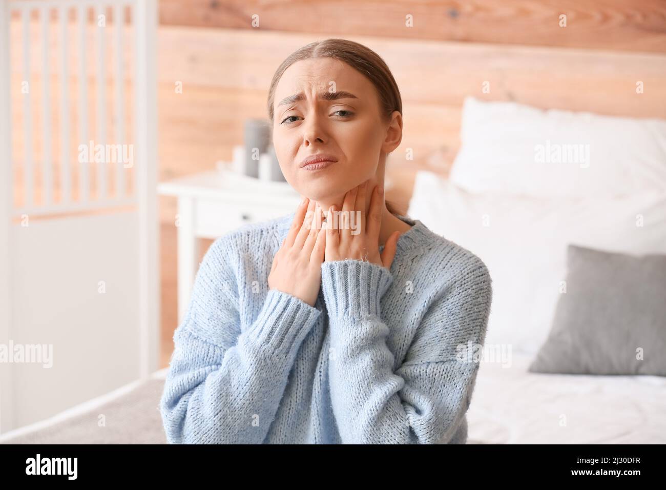 Ill young woman with sore throat at home Stock Photo Alamy