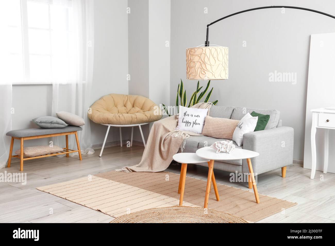 Interior of light living room with coffee tables, sofa and lamp Stock ...