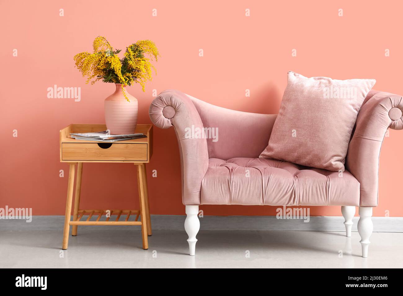 Vase with mimosa flowers on table and sofa in interior of room Stock ...