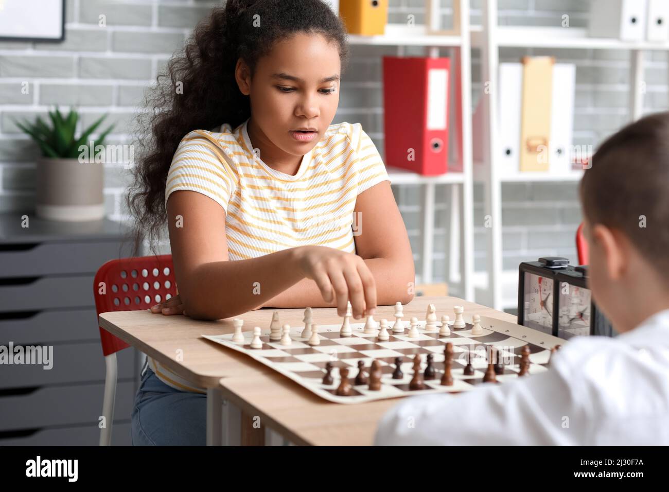 Little children playing chess during tournament in club Stock Photo - Alamy