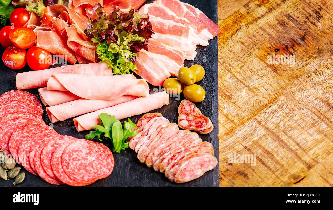 Assortment of salami prosciutto meats and sausages, olives and spices