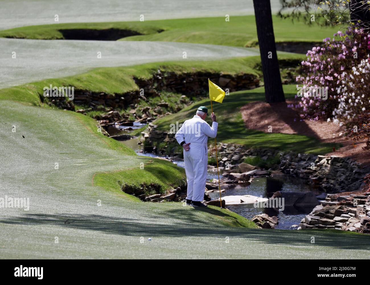 Augusta, United States. 04th Apr, 2022. A caddie holds a flag to mark the area where a ball lands Rae's Creek on the 13th hole during a practice round leading up to the Masters golf tournament at Augusta National Golf Club in Augusta, Georgia on Monday, April 4, 2022. Photo by John Angelillo/UPI Credit: UPI/Alamy Live News Stock Photo