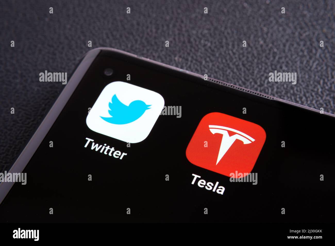 Twitter and Tesla apps seen on the corner of smartphone. Concept for Elon Musk buying shares of Twitter. Stafford, United Kingdom, March 4, 2022. Stock Photo