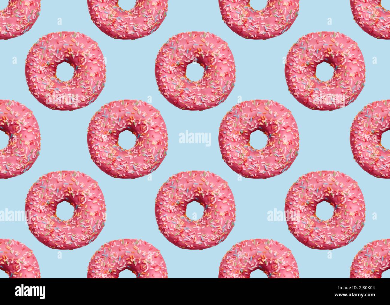 Pink glazed doughnuts with icing on light blue backdrop Stock Photo
