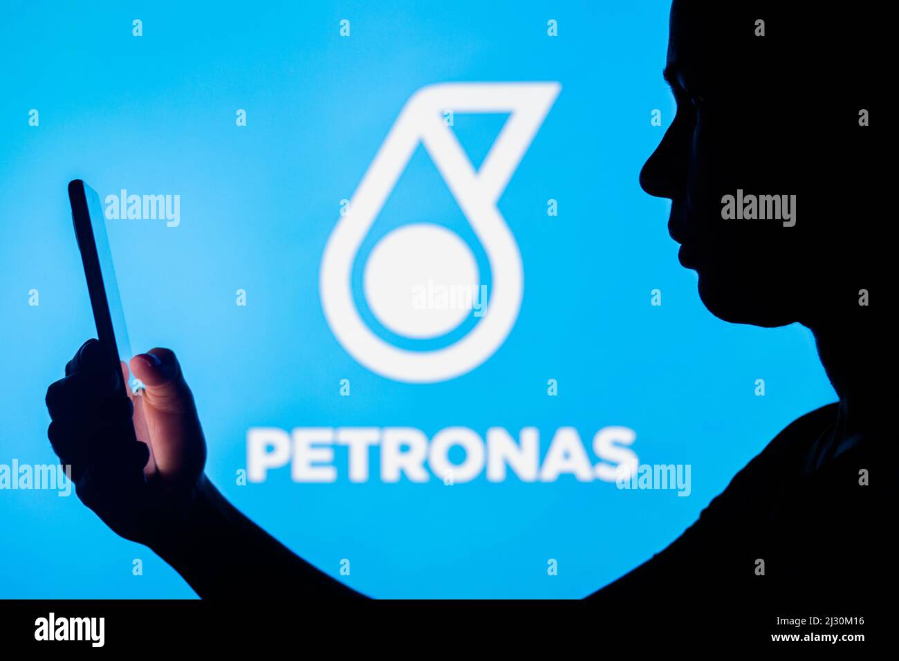 Brazil. 4th Apr, 2022. In this photo illustration, a woman's silhouette holds a smartphone with the Petronas logo in the background. (Credit Image: © Rafael Henrique/SOPA Images via ZUMA Press Wire) Stock Photo