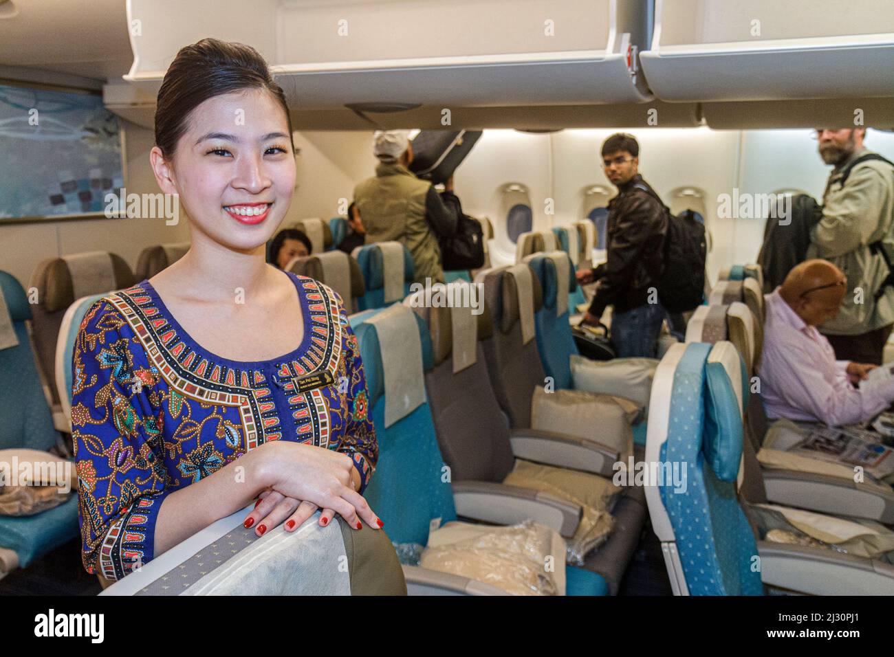 San Francisco California,International Airport,Singapore Airlines,passenger cabin,Asian woman female attendant boarding passengers economy class seats Stock Photo