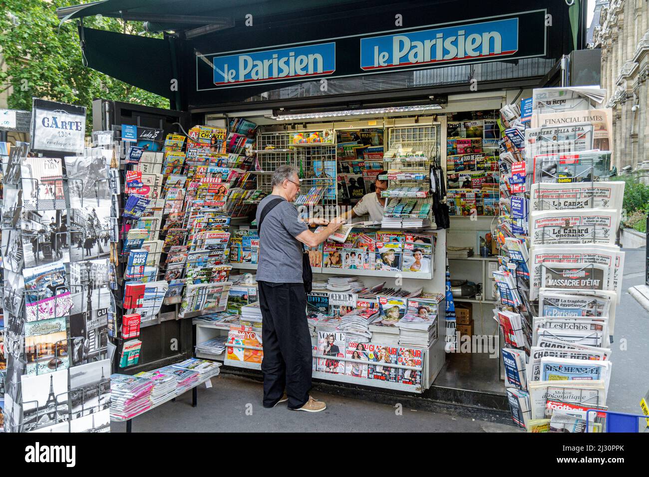 Paris France,4th arrondissement,Rue de Rivoli,newsstand newspapers magazines display sale man buying Stock Photo