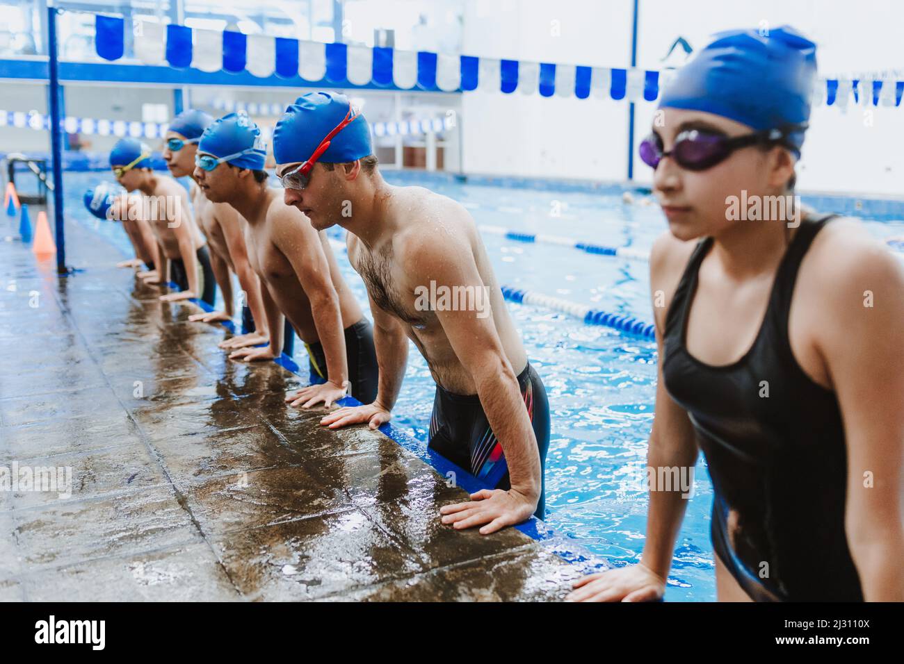 latin child boy swimmer wearing cap and goggles in a swimming training at the Pool in Mexico Latin America Stock Photo
