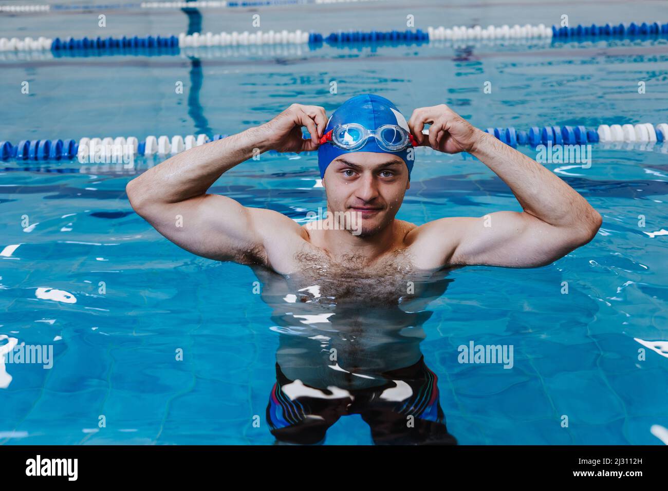hispanic young man swimmer athlete wearing cap in a swimming training at the Pool in Mexico Latin America Stock Photo