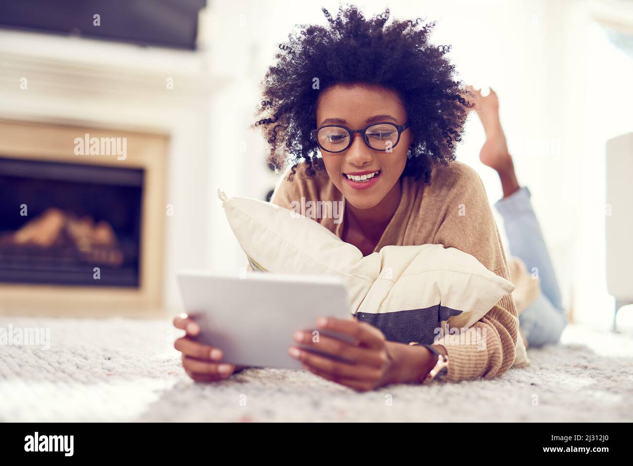 The perfect weekend is just an ebook away. Shot of a young woman using a digital tablet at home. Stock Photo