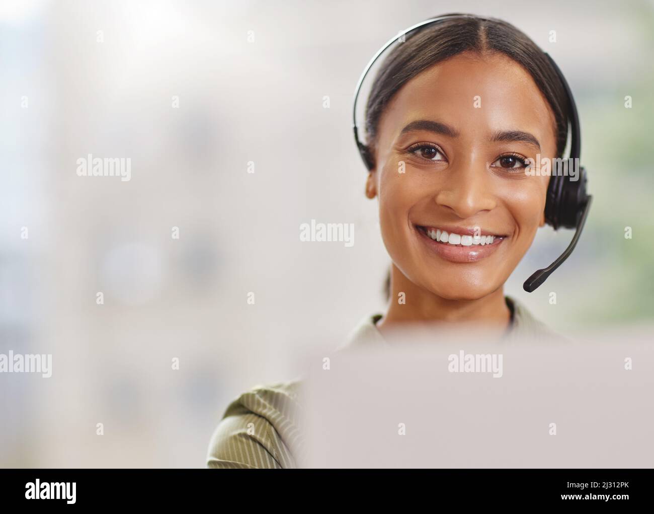 Im ready to make your day. Shot of a call centre agewnt smiling while sitting at her desk. Stock Photo