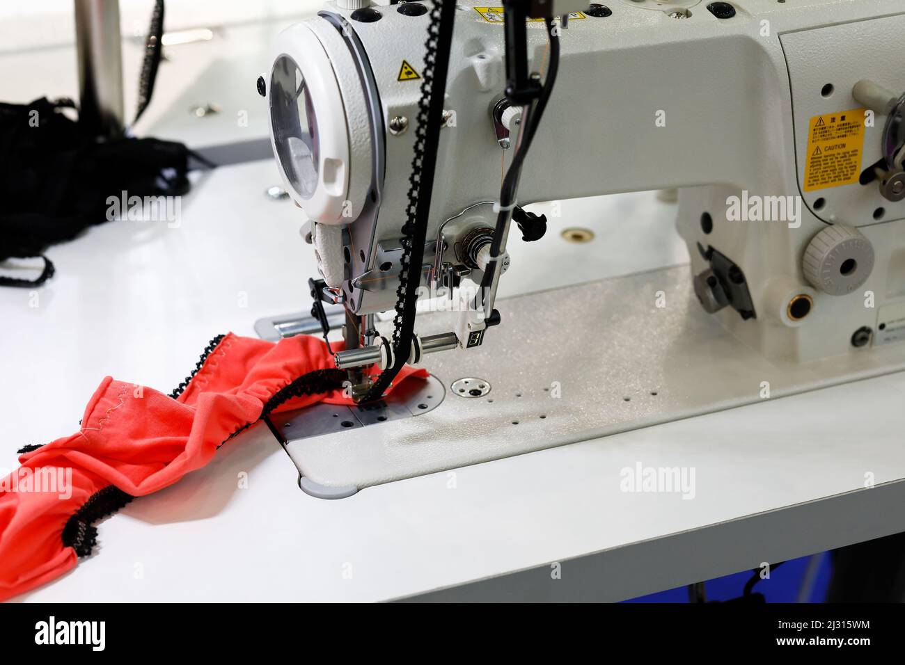 Industrial sewing machine for lace attachment. Selective focus. Stock Photo