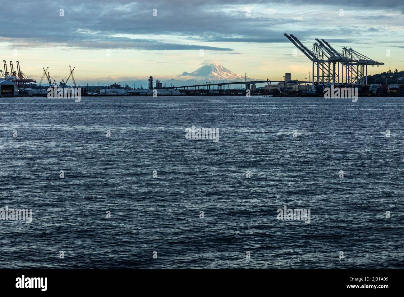 Looking across the waters of Elliott Bay toward the West Seattle Bridge, Harbor Island, and Mount Rainier. Stock Photo