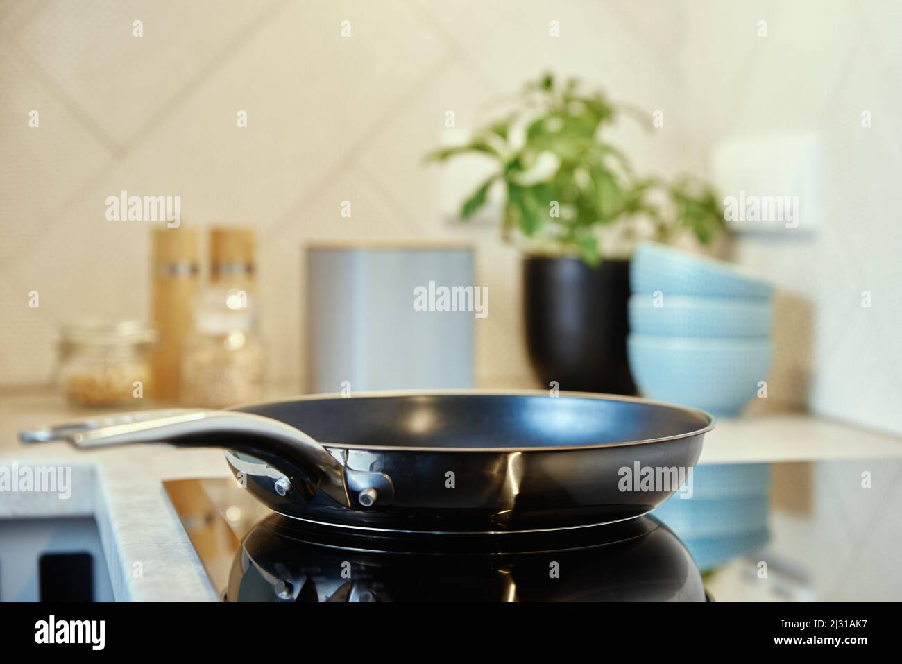 Steel frying pan in the kitchen on electric induction hob, Modern