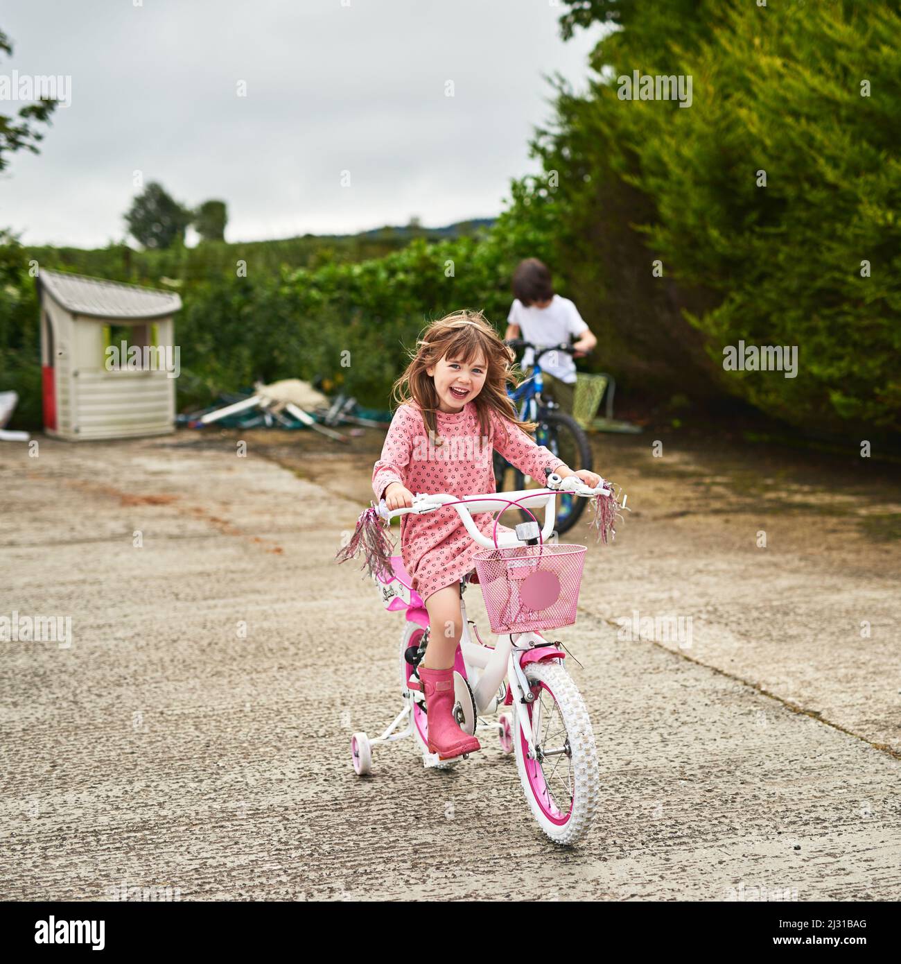 Young girl riding bicycle with training wheels hi res stock photography and images Alamy