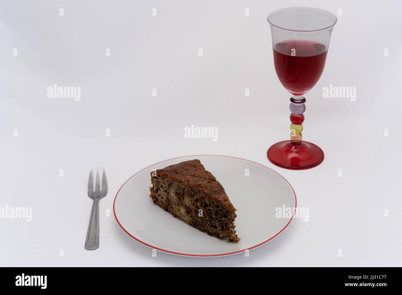Homemade dessert. Yogurt cake with apples and chocolate in a plate, with a fork and a glass of wine Stock Photo