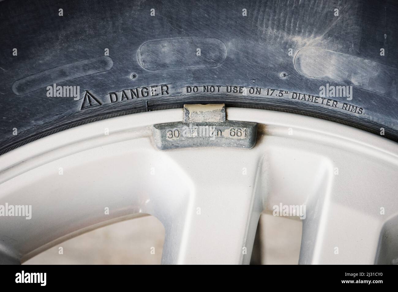 Wheel balancing weight clip on the grey car alloy rim Stock Photo Alamy