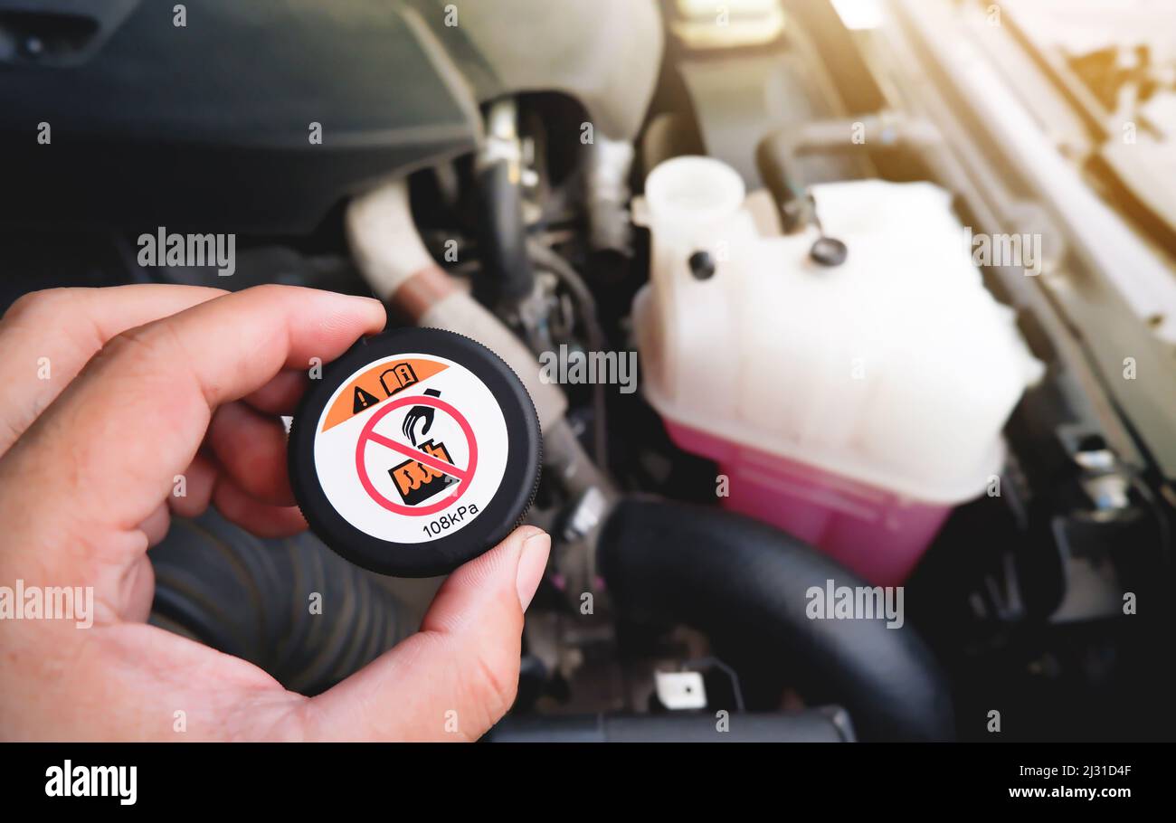 A mechanic hand is clutching a radiator cap with a high temperature ...