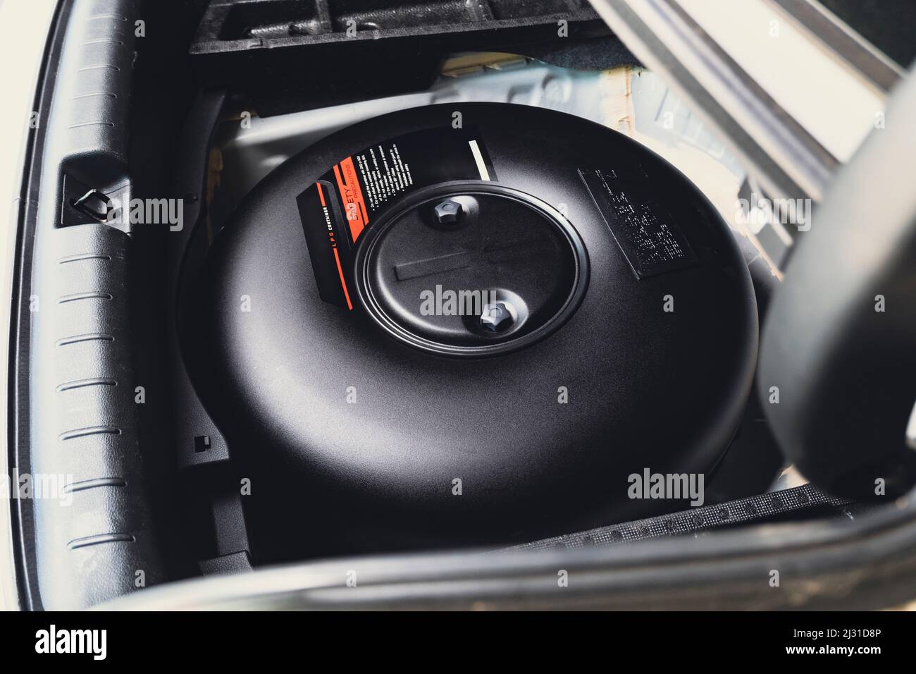 Car donutshaped LPG tank in a spare wheel hole on the car trunk Stock