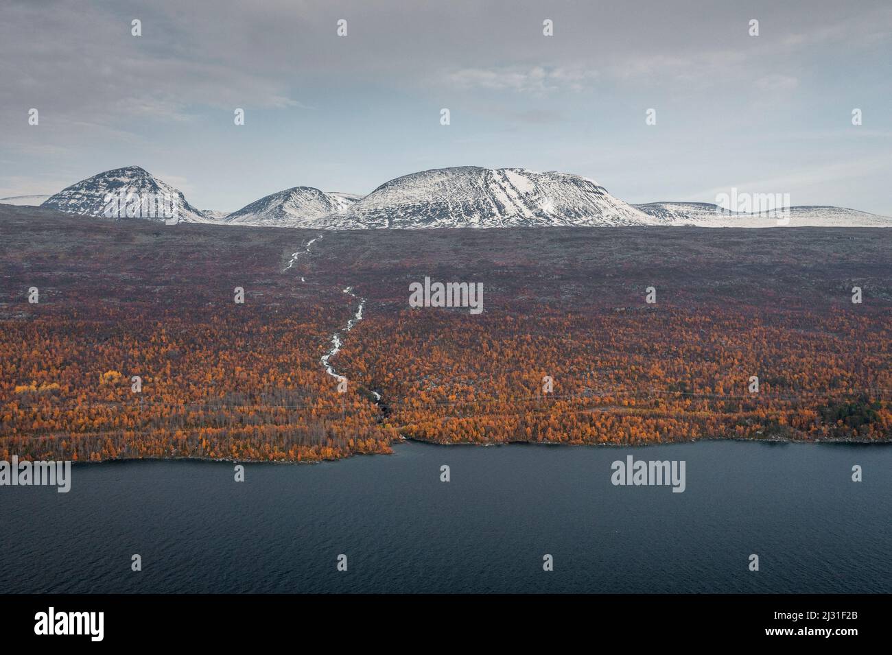 Landscape with snowy mountains and river to the lake in Stora Sjöfallet National Park in autumn in Lapland in Sweden Stock Photo