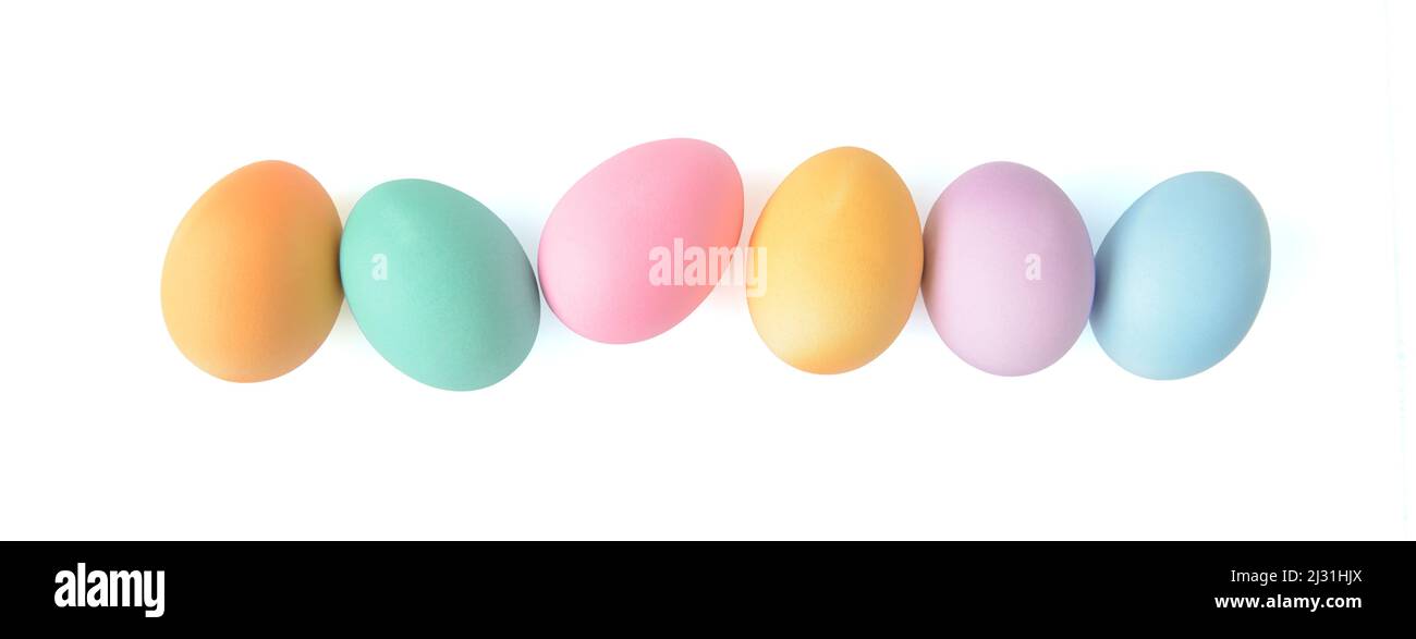 Pastel coloured Easter eggs in a line row isolated on white background, top view Stock Photo