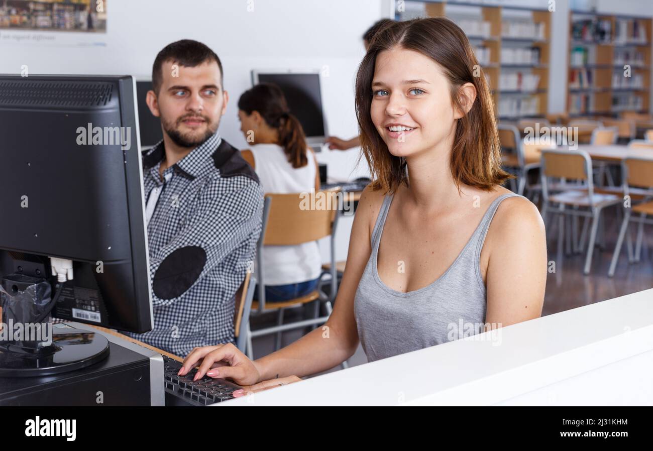 Girl using pc in library Stock Photo - Alamy