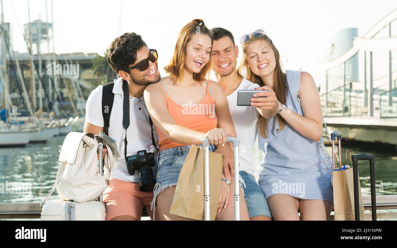 group travellers taking selfie on smartphone on waterfront Stock Photo