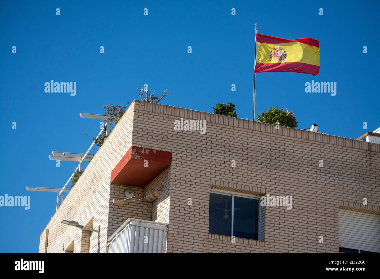 Apartment block with Spanish flag flying on the roof Stock Photo