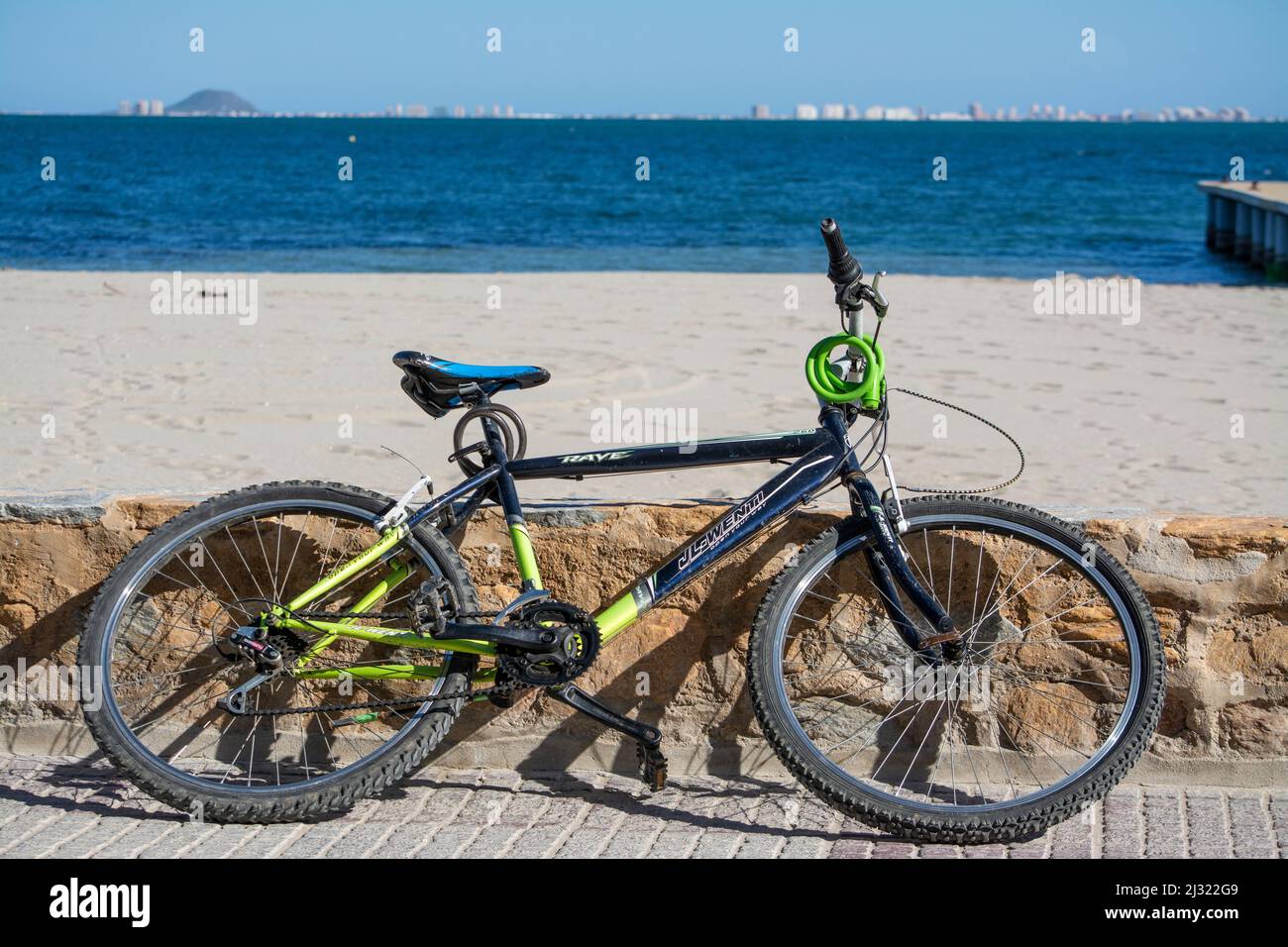 Bicycle leaning on the promenade wall on the Mar Menor, Murcia, Spain Stock Photo