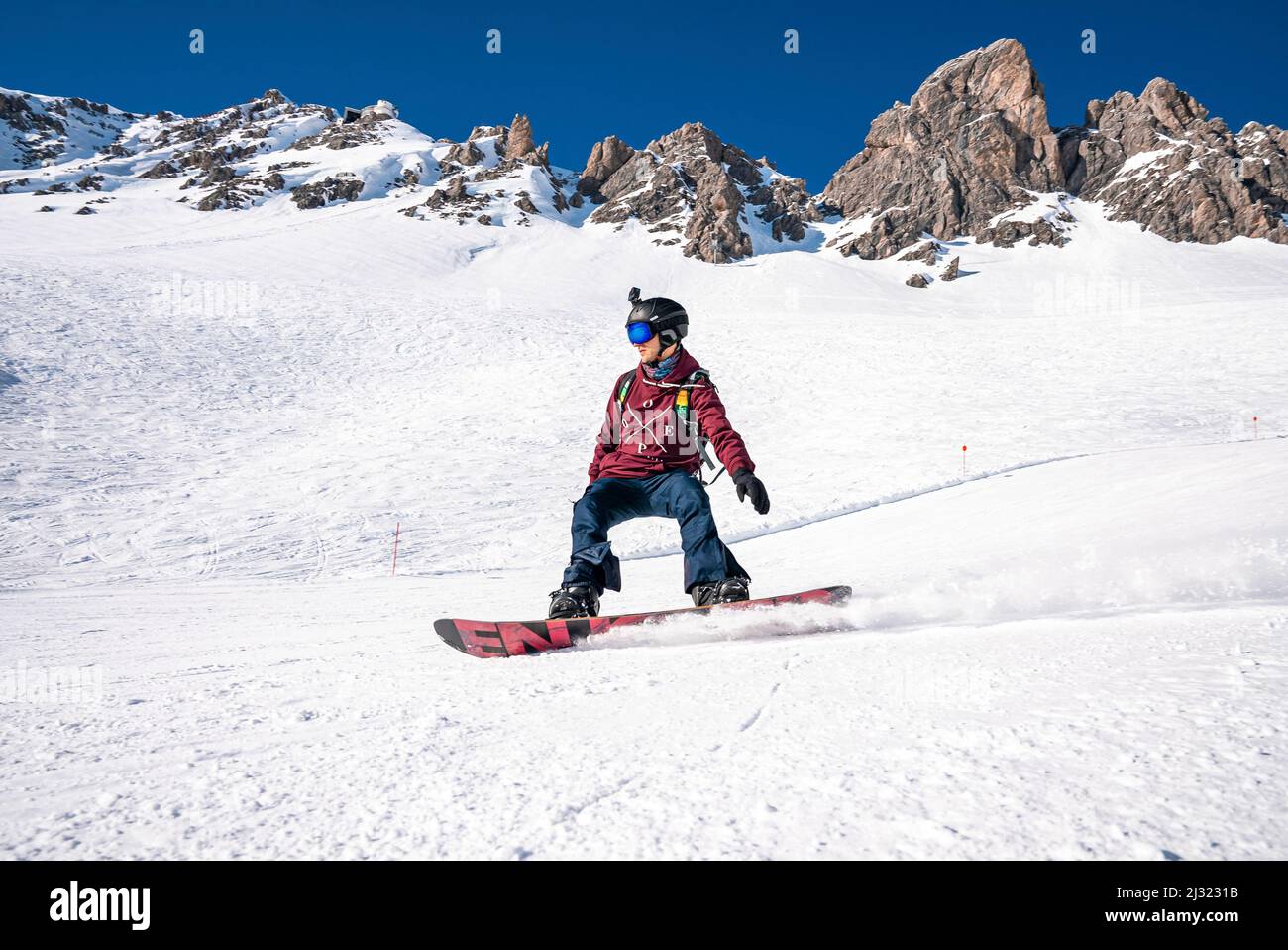 Young snowboarder sliding down snowy slope on mountain at winter resort  Stock Photo - Alamy