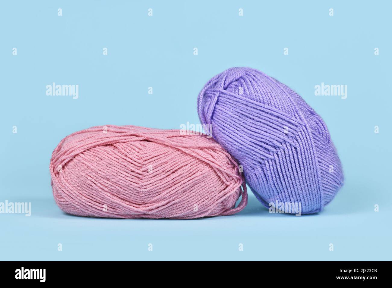 Pink and purple balls of wool on blue background Stock Photo
