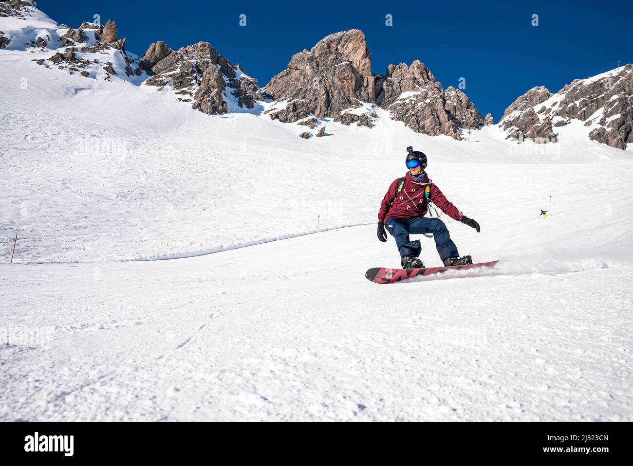 Young snowboarder sliding down snowy slope on mountain at winter resort  Stock Photo - Alamy